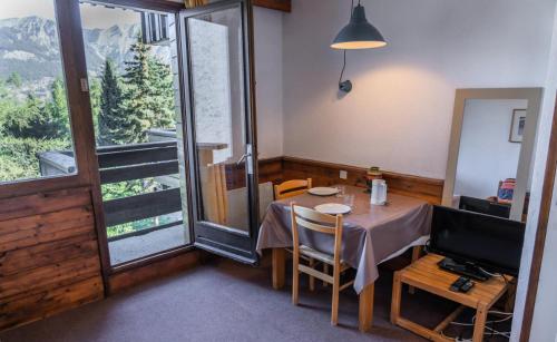 une salle à manger avec une table et une grande fenêtre dans l'établissement Résidence Le Belvedere - Studio au coeur des Orres 1650 MAE-6944, aux Orres