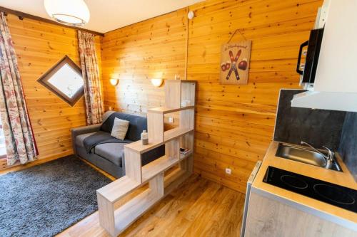 a living room with a couch in a log cabin at Résidence Le 1650 - Studio 964 in Les Orres