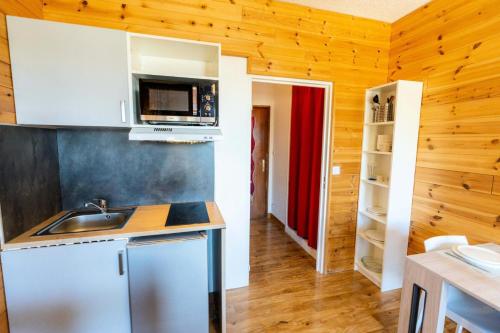 a kitchen with a sink and a microwave at Résidence Le 1650 - Studio 964 in Les Orres
