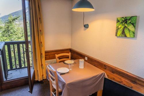 une salle à manger avec une table et un balcon dans l'établissement Résidence Le Belvedere - Studio au coeur des Orres 1650 MAE-6974, aux Orres