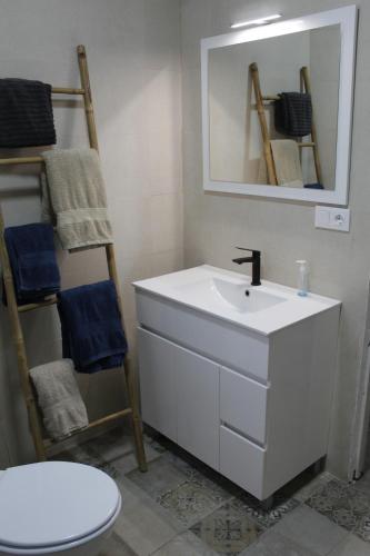 y baño con lavabo, espejo y aseo. en Chalet vacacional, en Hondón de las Nieves