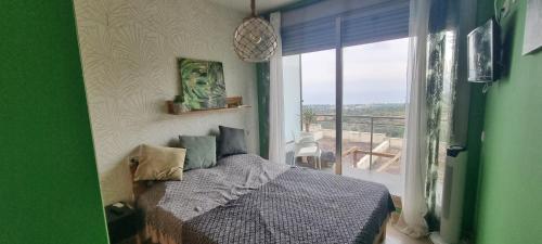 een slaapkamer met een bed en uitzicht op een balkon bij Peñiscola - Casa Mirador mit Gemeinschaftspool in Castellón de la Plana