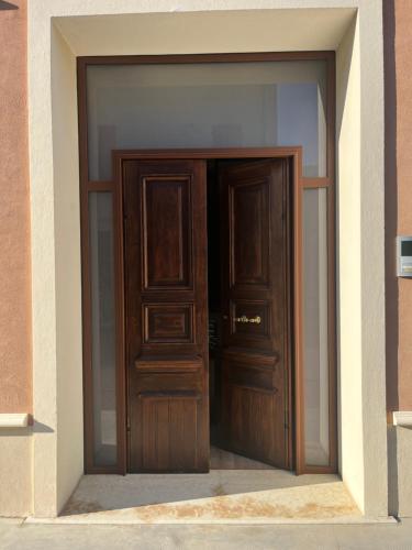 une grande porte en bois dans un bâtiment dans l'établissement Casa & Bottega, à Rivarolo Mantovano