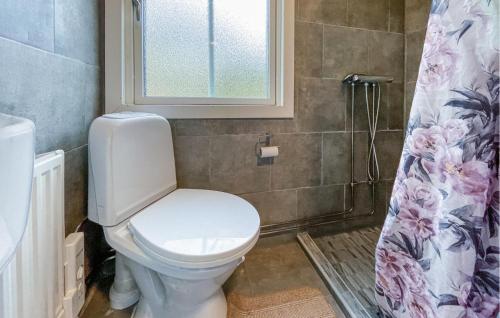 a bathroom with a toilet and a shower curtain at Lovely Home In Lnghem With Kitchen in Länghem
