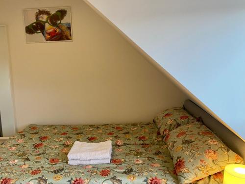 ein Bett mit einer Bettdecke und einem Handtuch darauf in der Unterkunft gemütliches Dachgeschoss in Bonn