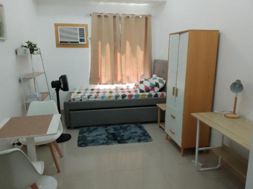 Cette petite chambre comprend un lit et une fenêtre. dans l'établissement HOMELY Green 2 residences DLSU EAC UMC, à Dasmariñas