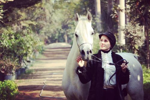 una mujer parada junto a un caballo blanco en Family House بيت العيلة en El Cairo