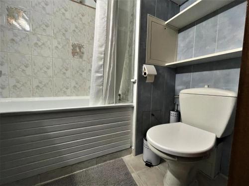 a bathroom with a toilet and a tub and a sink at Résidence Tougnette - Studio pour 3 Personnes 494 in Les Menuires
