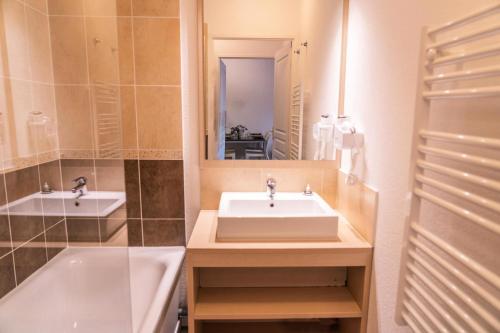 une salle de bain avec un lavabo, une baignoire et un miroir dans l'établissement Résidence Les Terrasses Du Soleil D'or - Appartement 2 pièces joliment rénové MAE-4314, aux Orres