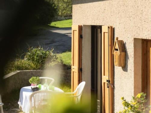 einen Tisch und Stühle auf einer Terrasse mit einem Tisch und einem Tisch in der Unterkunft Résidence Le Petit Nid - Maisons & Villas pour 7 Personnes 324 in Corrençon-en-Vercors