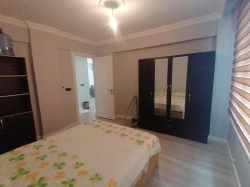 1 dormitorio con cama y espejo grande en Dalaman Apart Vacance , Ozgün Deniz Sitesi No 5, en Dalaman