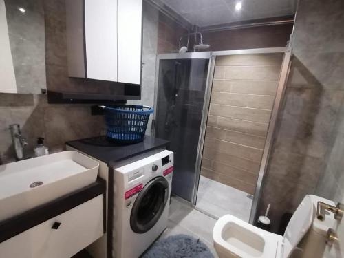 y baño con lavadora y lavamanos. en Dalaman Apart Vacance , Ozgün Deniz Sitesi No 5, en Dalaman