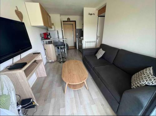 un salon avec un canapé noir et une table dans l'établissement Élégant T2 près du port et de la plage Cap d'Agde, au Cap d'Agde