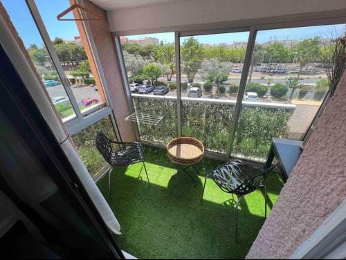 d'un balcon avec des chaises et une table offrant une vue sur la cour. dans l'établissement Élégant T2 près du port et de la plage Cap d'Agde, au Cap d'Agde