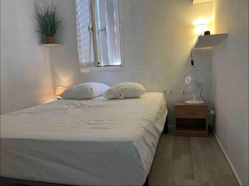 - une chambre dotée d'un lit avec deux oreillers et une lampe dans l'établissement Élégant T2 près du port et de la plage Cap d'Agde, au Cap d'Agde