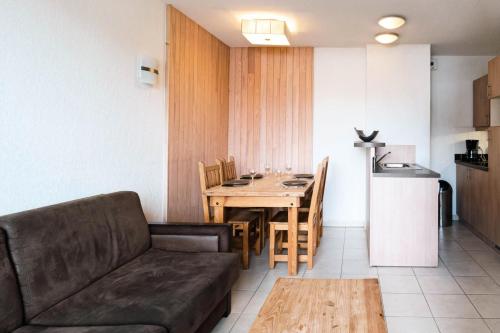 un salon avec un canapé et une table et une cuisine dans l'établissement Résidence Le Balcon Des Airelles - Appartement calme au cœur des Orres 1800 MAE-9364, aux Orres