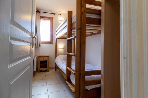 Cette petite chambre comprend des lits superposés et un lit. dans l'établissement Résidence Le Balcon Des Airelles - Appartement calme au cœur des Orres 1800 MAE-9364, aux Orres