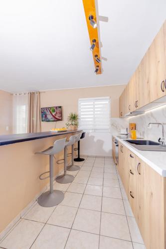 a kitchen with wooden cabinets and a counter top at Sarita's Apartments & Suite in Laganas