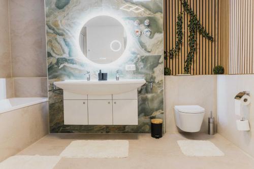 a bathroom with a sink and a toilet and a mirror at Luxury 4 Bedroom Apartment/Therme Erding/Parking in Erding