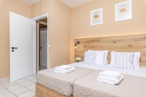 a bedroom with a white bed with towels on it at Sarita's Apartments & Suite in Laganas
