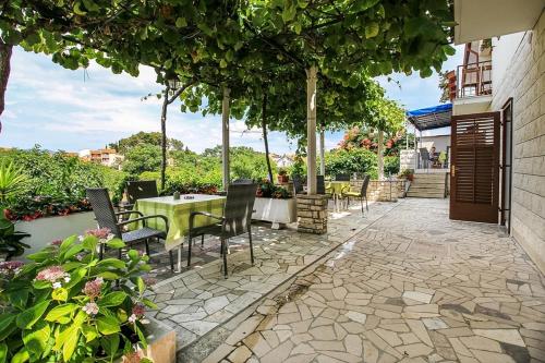 eine Terrasse mit einem Tisch, Stühlen und Bäumen in der Unterkunft Apartments by the sea Trpanj, Peljesac - 16004 in Trpanj