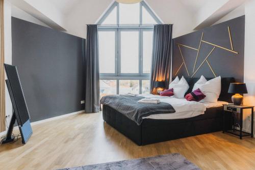 sypialnia z dużym łóżkiem i dużym oknem w obiekcie Luxury 4 Bedroom Apartment/Therme Erding/Parking w mieście Erding