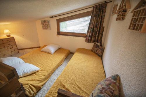 a bedroom with two beds and a window at Résidence Le Pouzenc - Studio pour 6 Personnes 424 in Les Orres