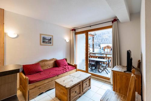 un salon avec un canapé rouge et un balcon dans l'établissement Résidence Le Balcon Des Airelles - Appartement calme au cœur des Orres 1800 MAE-9414, aux Orres