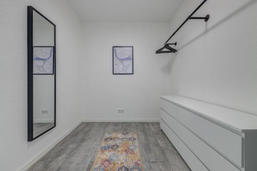 a room with white walls and a staircase with mirrors at Zentrale Design Wohnung in Ufernähe - 105 qm - Parkplatz - Küche - Netflix in Bingen am Rhein