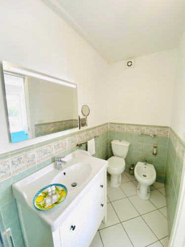 a bathroom with a sink and a toilet and a mirror at Casa Pippo 1 in Anacapri