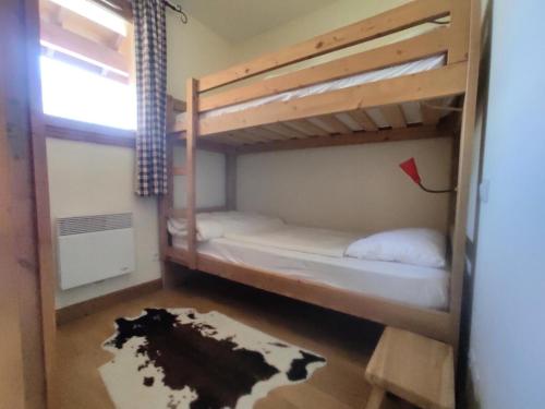Cette chambre dispose de lits superposés avec 2 lits superposés et un tapis. dans l'établissement Les Chalets Des Rennes - Appartement cozy 3 pièces - Les Chalets Des Rennes MAE-9474, à Vars