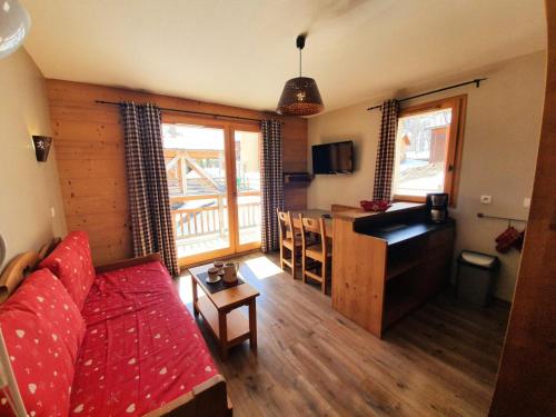 un salon avec un canapé rouge et une cuisine dans l'établissement Les Chalets Des Rennes - Appartement 2 pièces - Les Chalets Des Rennes MAE-9534, à Vars