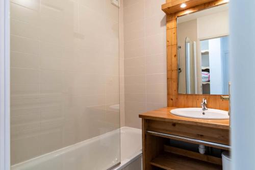 une salle de bain avec un lavabo, une baignoire et un miroir dans l'établissement Résidence Le Balcon Des Airelles - Appartement calme au cœur des Orres 1800 MAE-9484, aux Orres