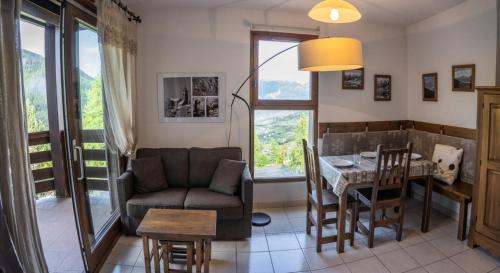 - un salon avec une table, une chaise et un canapé dans l'établissement Résidence Le Balcon De Pramouton - Appartement 2 pièces paisible aux Orres 1550 MAE-9544, aux Orres