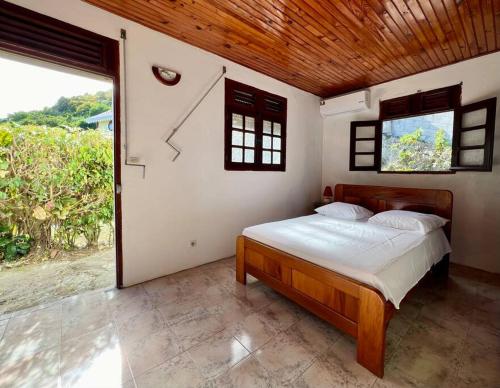 um quarto com uma cama e um relógio na parede em VILLA DES PALMIERS em Le Marin