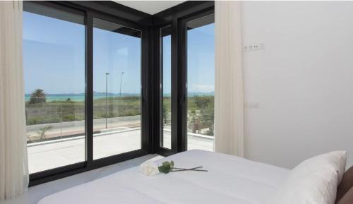 Un dormitorio con una cama blanca y una ventana grande. en LA Paradise, en Los Alcázares