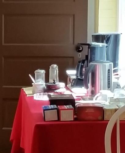 a table with a red table cloth with a coffee maker on it at Mountain Home Bed & Breakfast in Front Royal