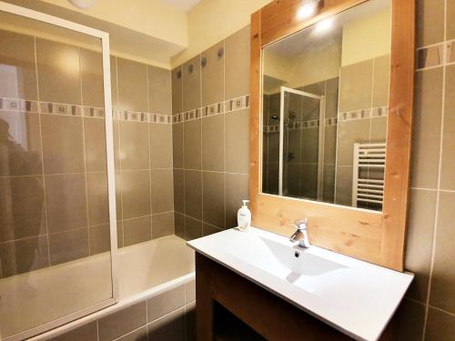 ein Bad mit einem Waschbecken, einer Dusche und einem Spiegel in der Unterkunft Les Chalets Des Rennes - 2 Pièces pour 4 Personnes 614 in Vars