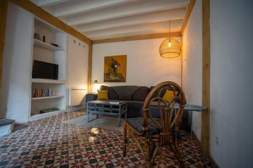 ein Wohnzimmer mit einem Sofa und einem Tisch in der Unterkunft Lovely house with courtyard and terrace near canal du Midi in Trèbes