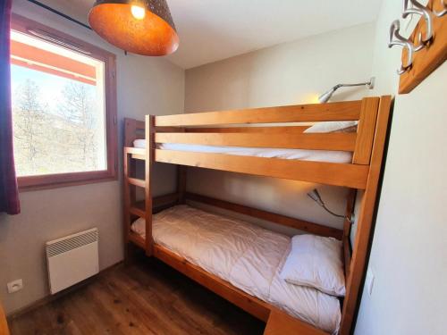 deux lits superposés dans une chambre avec fenêtre dans l'établissement Les Chalets Des Rennes - Appartement 6 personnes - Les Chalets Des Rennes MAE-9624, à Vars