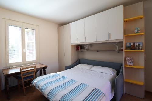 1 dormitorio con cama, escritorio y ventana en Curt di Sciàtt en Monza