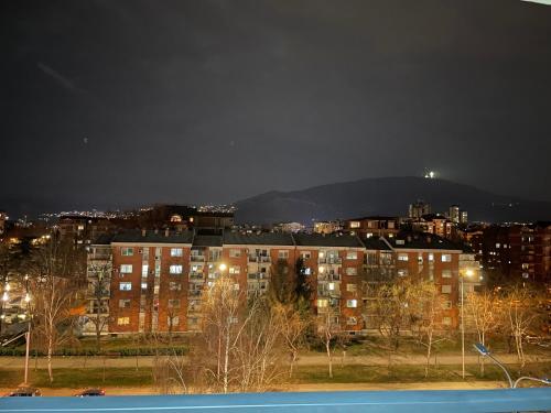 vistas a una ciudad por la noche con edificios en Urban LEKS apartment, en Skopje