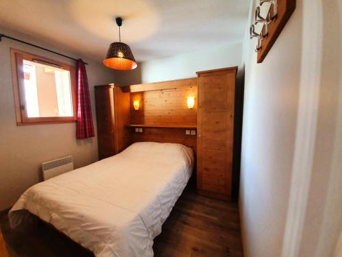 une petite chambre avec un lit et une fenêtre dans l'établissement Les Chalets Des Rennes - Appartement 2 pièces - Les Chalets Des Rennes MAE-9694, à Vars