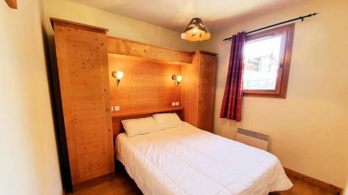 une petite chambre avec un lit blanc et une fenêtre dans l'établissement Les Chalets Des Rennes - Appartement 2 pièces - Les Chalets Des Rennes MAE-9684, à Vars