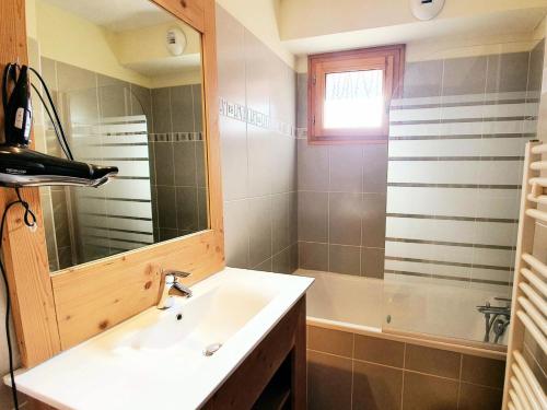 une salle de bain avec un lavabo, un miroir et une baignoire dans l'établissement Les Chalets Des Rennes - Appartement 2 pièces - Les Chalets Des Rennes MAE-9684, à Vars