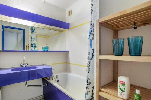 La salle de bains est pourvue d'un lavabo bleu et d'une baignoire. dans l'établissement Résidence Port du Crouesty - maeva Home - Appartement 2 pièces 6 personnes - Confort MAE-5369, à Arzon