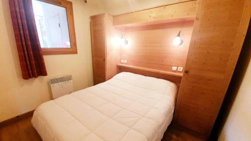 een kleine slaapkamer met een bed en een raam bij Les Chalets Des Rennes - 2 Pièces pour 4 Personnes 734 in Vars