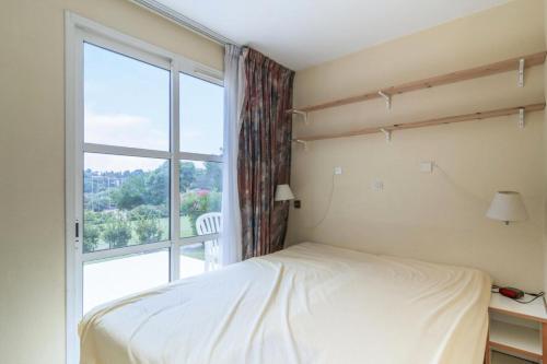 une chambre avec un lit et une grande fenêtre dans l'établissement Résidence le Village de Cap Esterel - maeva Home - Appartement 3 Pièces 6 Personnes - Budget MAE-5941, à Saint-Raphaël
