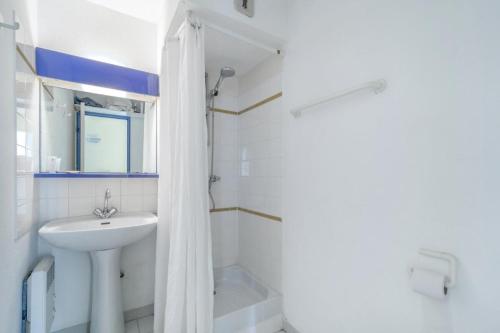 une salle de bain blanche avec un lavabo et une douche dans l'établissement Résidence le Village de Cap Esterel - maeva Home - Appartement 3 Pièces 6 Personnes - Budget MAE-5941, à Saint-Raphaël