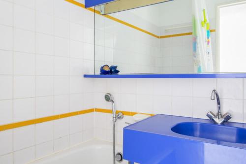 une salle de bain avec un lavabo bleu et un miroir dans l'établissement Résidence le Village de Cap Esterel - maeva Home - Appartement 2 Pièces 5 Personnes - Confort MAE-5960, à Saint-Raphaël
